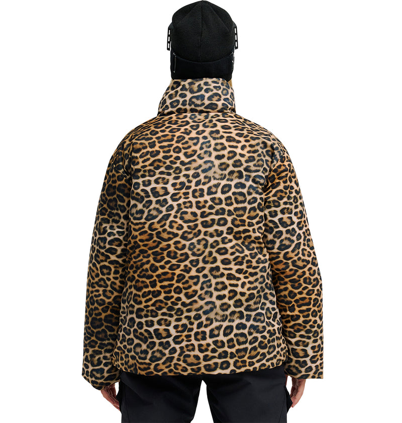 A person wearing a black hat and the DC Shoes Aura Puffer Jacket in leopard print is seen from behind, hands by their sides. This striking look merges effortless style with breathable protection, set against a plain white background.
