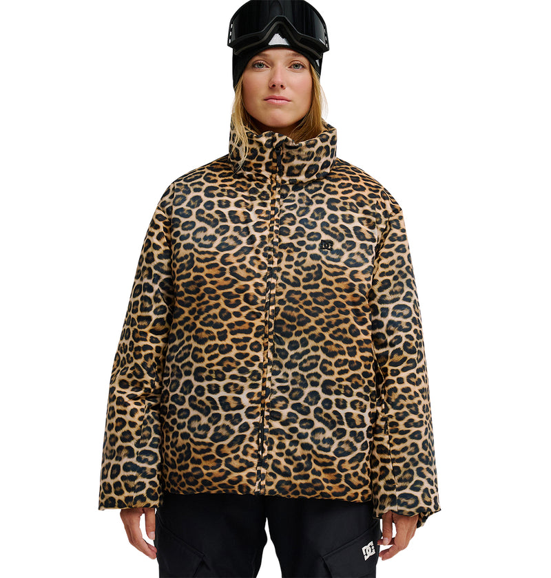 Clad in the DC Shoes Aura Puffer Jacket—a leopard-print, waterproof outer layer—paired with black snow pants and black ski goggles, this look merges bold style with breathable protection for peak snow performance against a white backdrop.