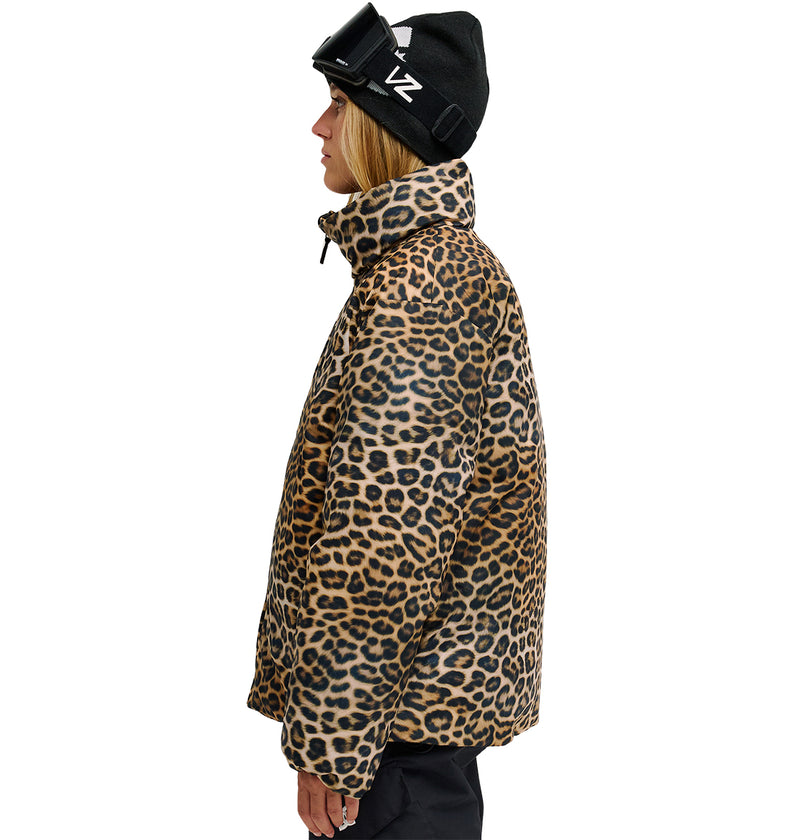 A person in profile wears the DC Shoes Aura Puffer Jacket in leopard print, paired with a black beanie and ski goggles pushed up on their head. The background is plain white.