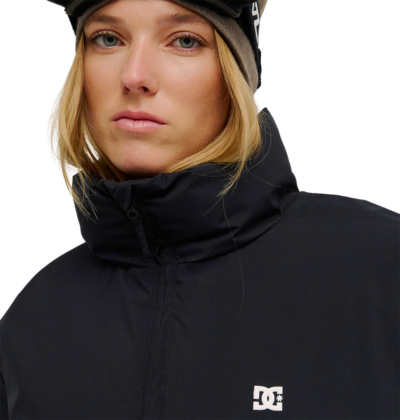A person wearing a black Aura Puffer Jacket by DC Shoes and a beanie, looking directly at the camera with a neutral expression. The DC Shoes logo is visible on the jacket.