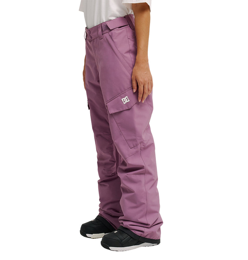 A person is wearing DC Shoes Nonchalant Pants—loose-fitting, lilac insulated snow pants featuring a side pocket with a logo patch—paired with black snow boots. The pants are designed for optimal snow performance. The individual’s face and upper body are not visible.