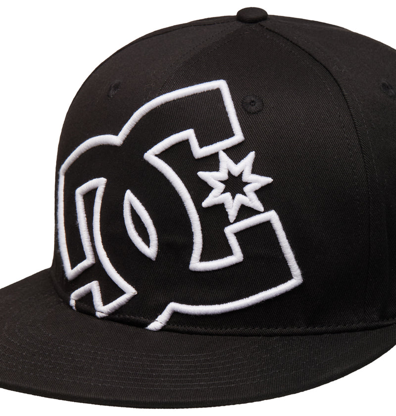 The Reebok DC Double That Cap is a black flat-brim baseball cap featuring a large white embroidered DC Shoes logo with a star on the front panel.
