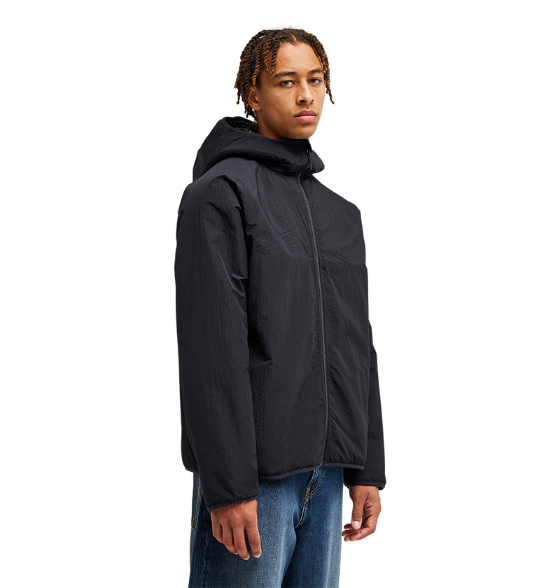 A person wearing the DC Shoes Coldstag Sherpa Reversible fleece jacket in black with blue jeans stands facing slightly left against a plain white background, showcasing cold-weather comfort.