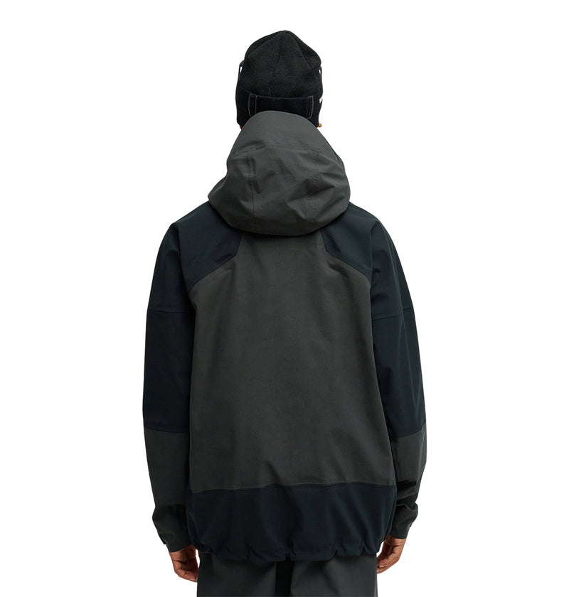 A person wearing the DC Shoes Storm Division 3L Jacket 30K, paired with a black beanie, is standing with their back to the camera against a plain white background.