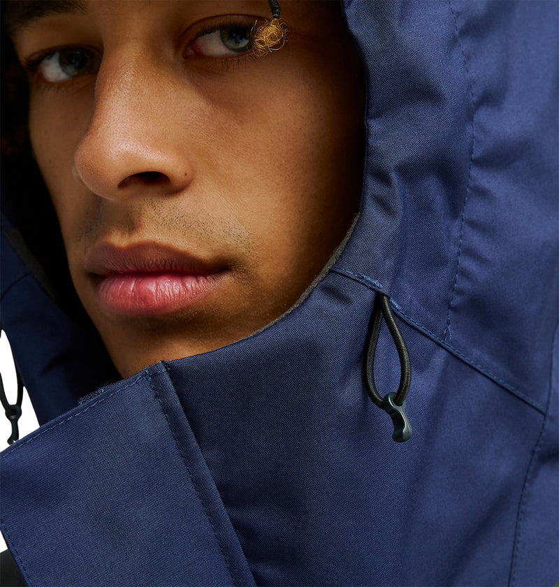 Close-up of a person’s face wearing the DC Shoes Coldsmoke Jacket 10K in blue. The focus is on the lower half of the face and the jacket’s drawstrings, showcasing its breathable protection against the elements.