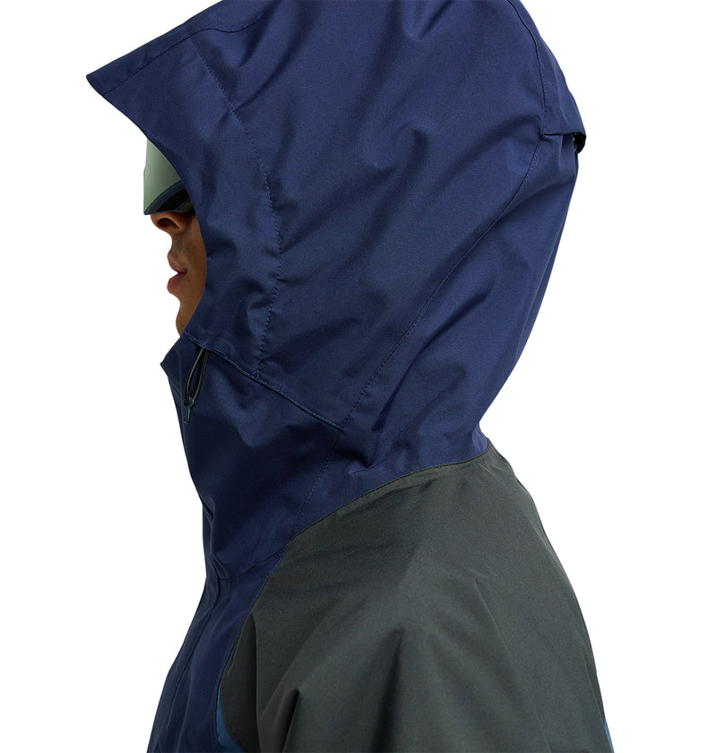 A person in profile, facing left, wears the DC Shoes Coldsmoke Jacket 10K—a large blue hooded jacket featuring breathable protection—paired with reflective sunglasses. The photo is cropped at the shoulders and set against a white background.