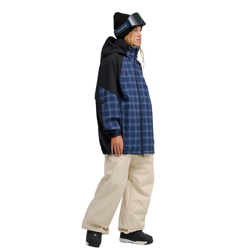 Person wearing a DC Shoes Trackstar Jacket 10K with breathable protection in blue plaid, paired with beige snow pants, black boots, a black beanie, and ski goggles, standing against a white background.