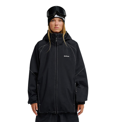 A person wearing the DC Shoes Trackstar Jacket 10K—a black snowboard jacket with breathable protection—paired with black snow pants, a black beanie, and ski goggles stands facing forward against a plain white background.