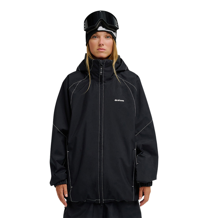 A person wearing the DC Shoes Trackstar Jacket 10K—a black snowboard jacket with breathable protection—paired with black snow pants, a black beanie, and ski goggles stands facing forward against a plain white background.