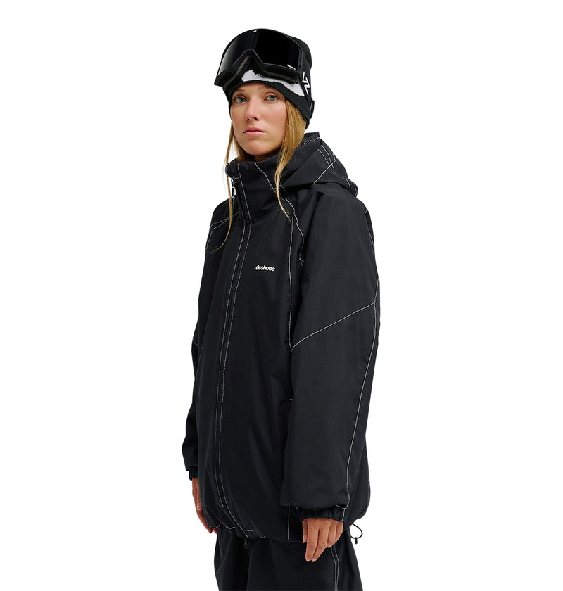 A person wearing the DC Shoes Trackstar Jacket 10K in black, along with black pants and ski goggles on their head—delivering breathable protection and reliable snow performance—stands facing forward with a neutral expression against a plain white background.