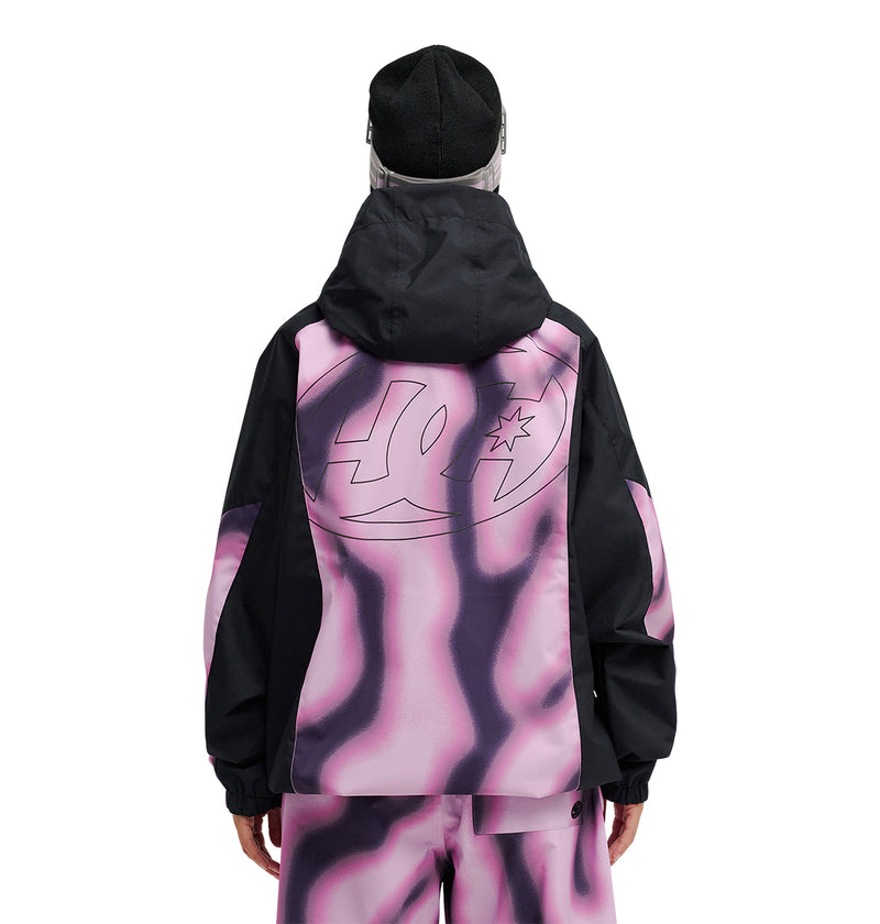 A person faces away, wearing a black hat and the DC Shoes Trackstar Jacket 10K, which features a large DC Shoes logo on the back. Both the jacket and matching pants showcase a wavy pink, purple, and black tie-dye pattern, and are designed for snow performance with breathable protection to ensure comfort in any conditions.