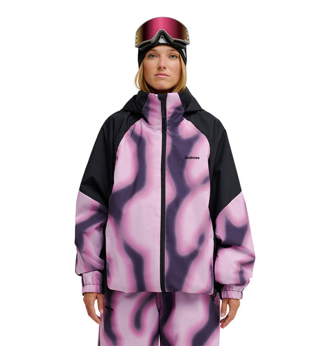 A person wearing the DC Shoes Trackstar Jacket 10K—a pink and black patterned ski jacket and pants offering breathable protection—along with a black hood and ski goggles, stands against a white background.