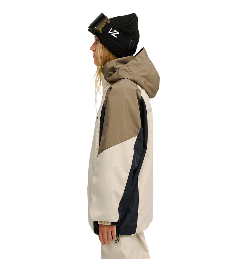 Wearing the DC Shoes Trackstar Jacket 10K in beige and tan, which offers breathable protection, along with matching pants and a black beanie topped with ski goggles, a person stands in profile against a white background.