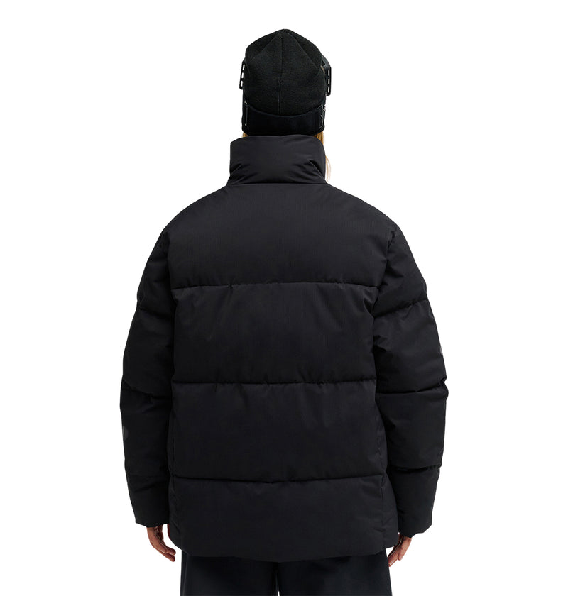 Wearing the DC Shoes Trackstar Puffer 10K jacket and a black beanie, a person stands with their back to the camera against a plain white background, highlighting both style and snow-ready performance.