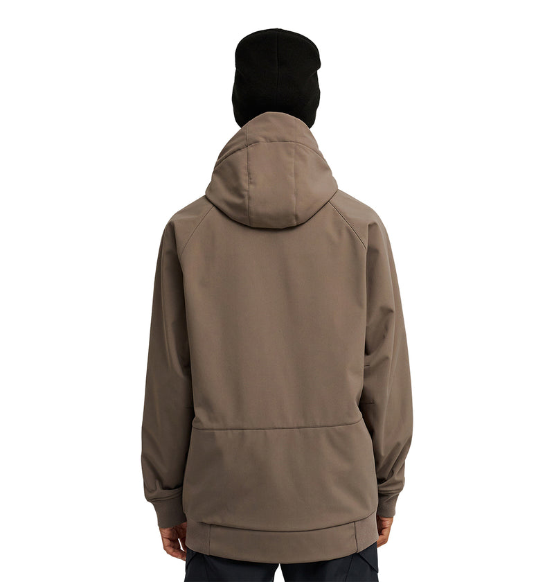A person wearing the DC Shoes Spectrum Softshell Jacket in taupe with a hood and a black beanie stands facing away, showcasing the back of the jacket against a white background.
