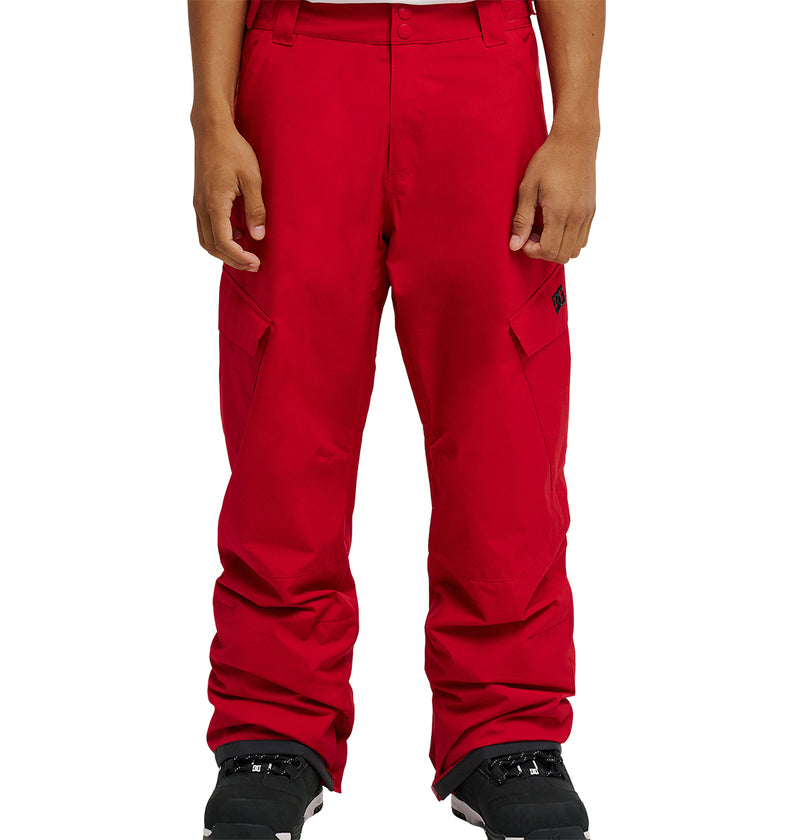 A person wearing bright red DC Shoes Banshee Pants and black snow boots, shown from waist to feet, standing against a plain white background.