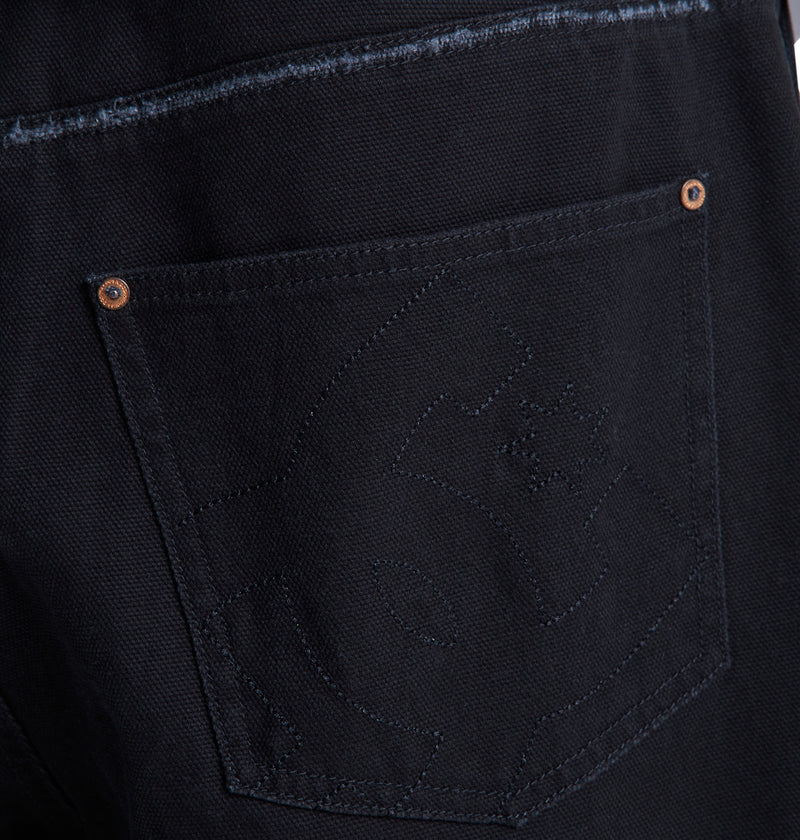 Close-up of the back pocket on Reebok's Stressed 5 Pocket dark denim jeans, showcasing visible stitching, small copper rivets at the corners, and a subtle stitched design on the pocket fabric.