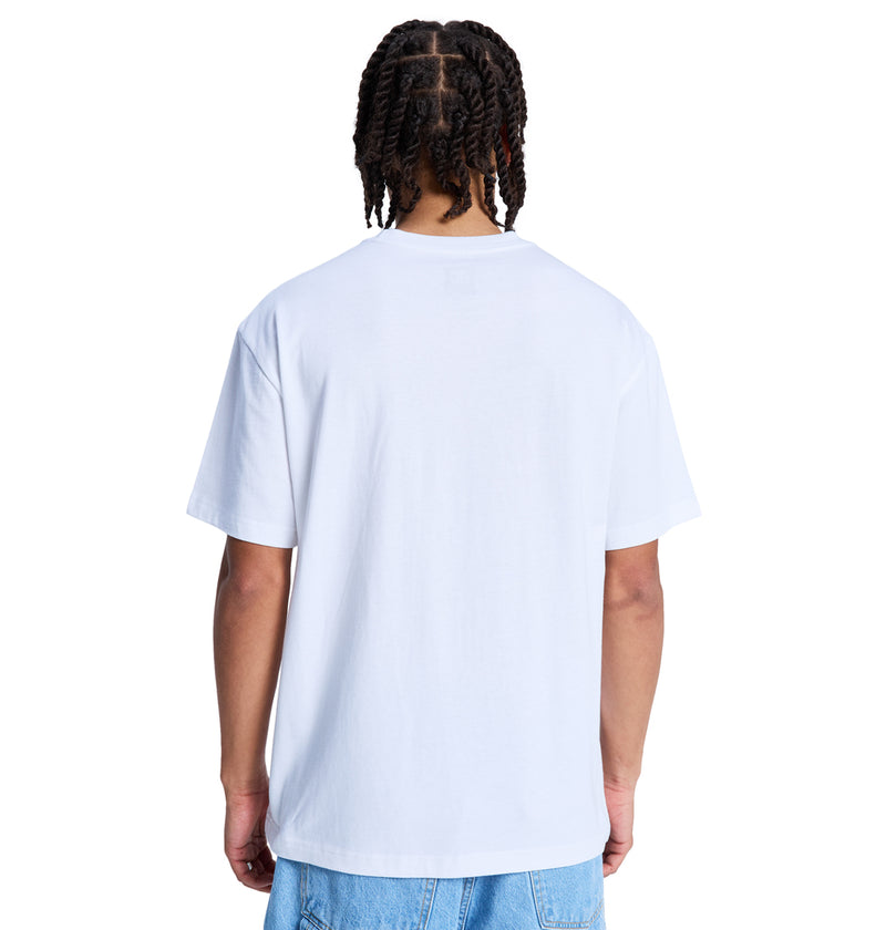 A person with braided hair, wearing the Reebok DC Star Filled Hss t-shirt and light blue jeans, stands with their back to the camera against a white background.