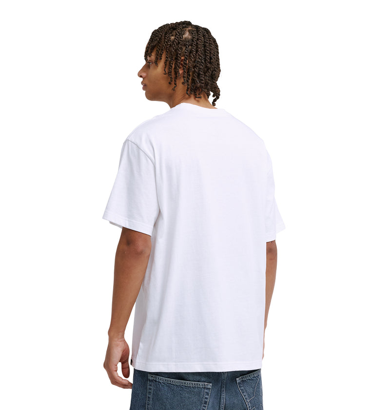 A person with short, curly hair is seen from behind wearing a plain white t-shirt, blue jeans, and Reebok Strike Twice Hss sneakers against a white background.