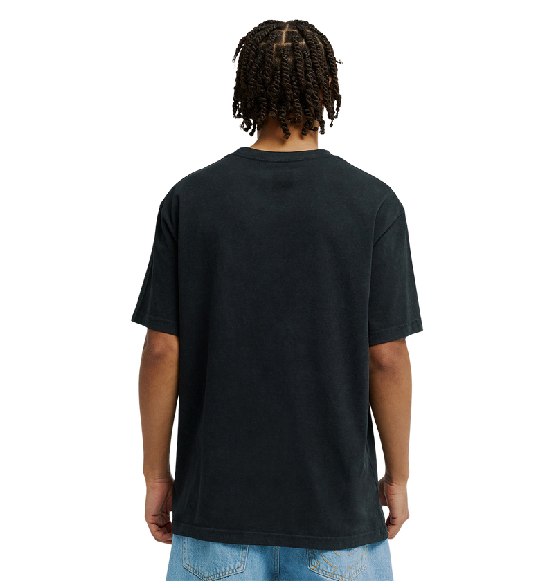 A person with short, twisted braids is shown from behind, wearing a relaxed fit black Men's DC Star Struck Tee by DC Shoes and light blue denim shorts against a plain white background.