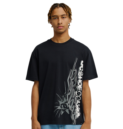A young man stands against a plain white background, facing forward with a neutral expression, wearing the Men's DC Side Flame Tee from DC Shoes—an eye-catching black graphic t-shirt showcasing bold white abstract graphics and signature DC SHOES CO. artwork, perfect for his next skate sessions.
