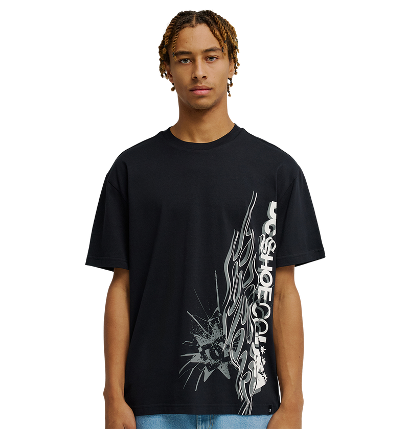 A young man stands against a plain white background, facing forward with a neutral expression, wearing the Men's DC Side Flame Tee from DC Shoes—an eye-catching black graphic t-shirt showcasing bold white abstract graphics and signature DC SHOES CO. artwork, perfect for his next skate sessions.