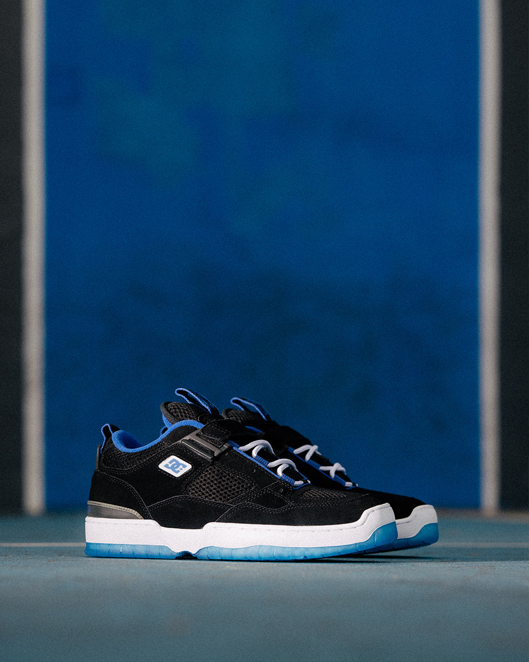 Black sneakers with blue accents on a blue background