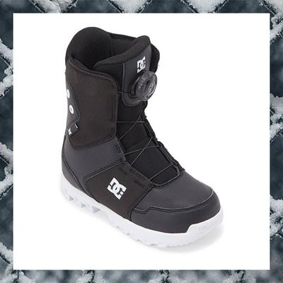 Black snow boot with white sole on a snowy background