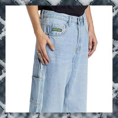 Light blue jeans with a brand logo on the pocket against a marble background