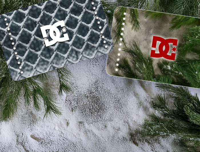 Two DC shoes gift cards with a frosted fence texture and a spruce branch texture on a snowy ground with evergreen trees in the background