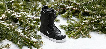 Black snow boot on a snowy branch