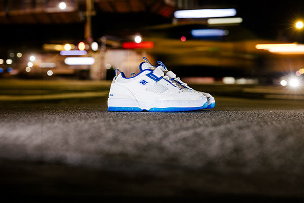 White and blue sneakers on a blurred street at night