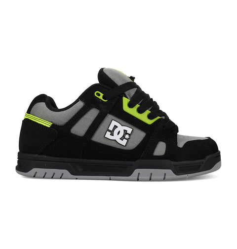 Black sneaker with green accents and a visible brand logo on a white background