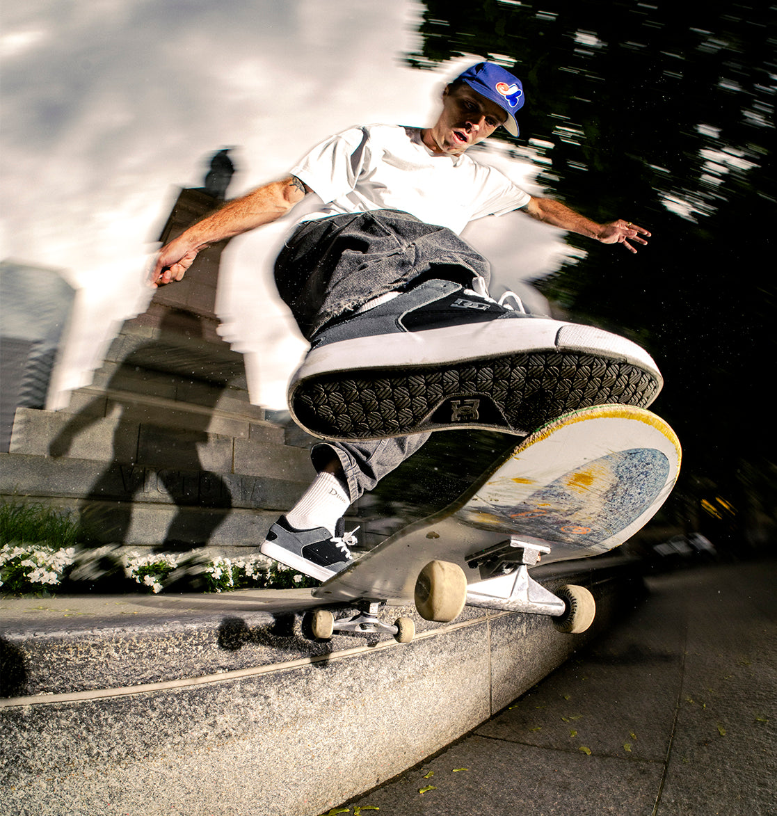 Skateboarder performing a trick on a skateboard with a blurred background