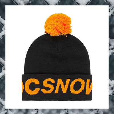 Black beanie with orange pom-pom and 'DC SNOW' text on a snowy background