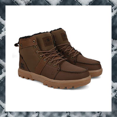 Pair of brown winter boots with fur lining on a textured white background