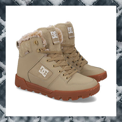 Beige high-top boots with brown soles on a textured white background